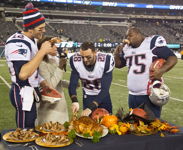 EAST RUTHERFORD, NJ - NOVEMBER 22: New England Patriots from left to right: Tom Brady, Steve Gregory, and Vince Wilfork join television broadcaster Michele Tafoya in eating turkey legs after defeating the New York Jets 49-19 at Metlife Stadium on Thursday, Nov. 22, 2012. (Photo by Matthew J. Lee/The Boston Globe via Getty Images)