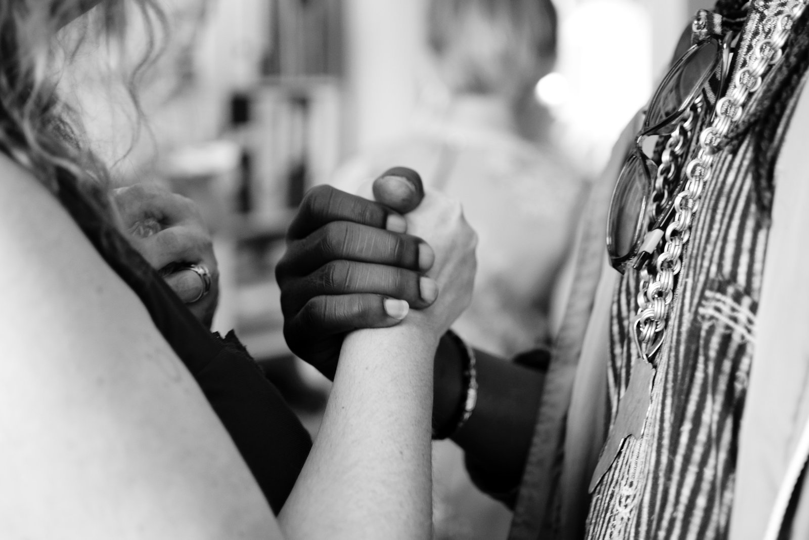 A Black person and a White person holding hands.