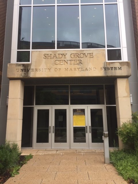 A yellowish stone entryway. The entry reads, "Shady Grove Center, University of Maryland System."