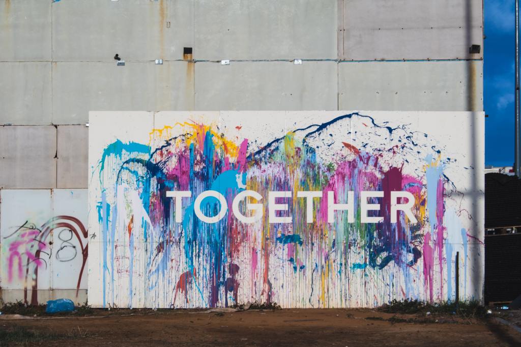 A billboard with rainbow paint and the word "together."