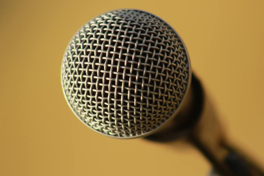 A microphone on a yellow background, facing you.