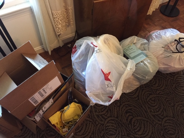 A large pile of stuff to donate. On top of the bags sits a play conveniently titled You Can't Take it With You.